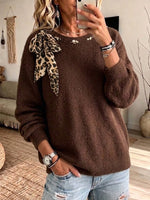 Elegante top de punto holgado con estampado de leopardo y detalles de lazo