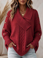 Maglione rosso da donna lavorato a trecce con colletto asimmetrico e maniche con bottoni