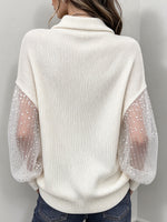 Elegante top in maglia con collo a lupetto e maniche in tulle trasparente